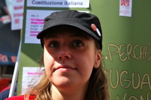 A woman in a hat stands in front of a board which shows information about MS