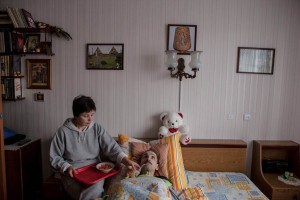 Woman feeds her husband, who has MS, in his bed