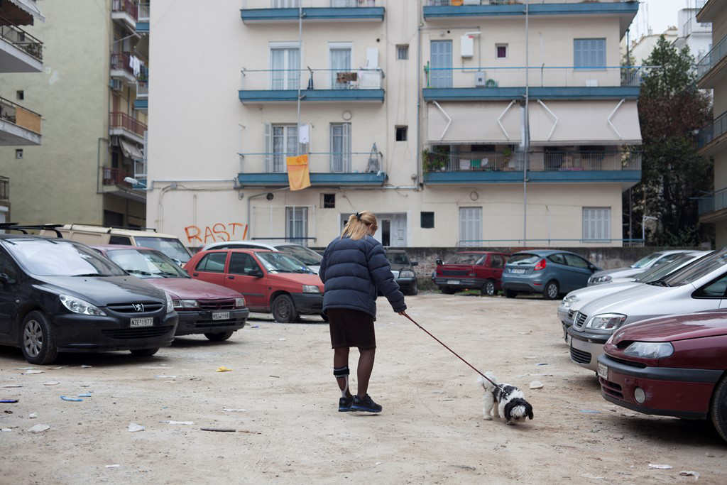 Woman with MS walking her dog next to some cars