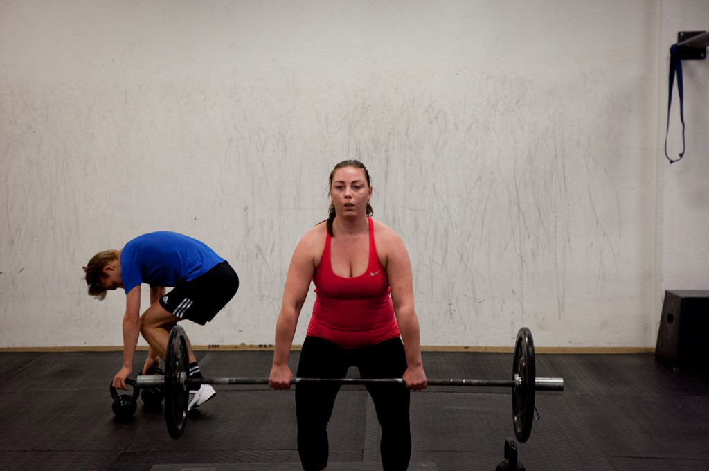A woman with MS lifting weights in the gym