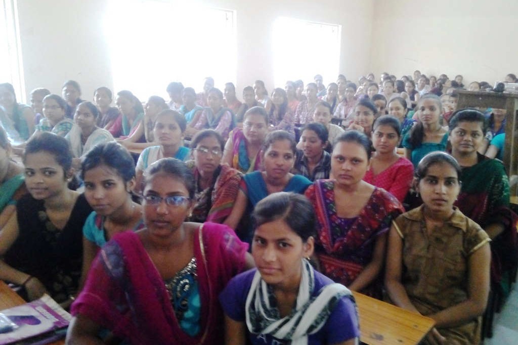 A classroom of young women in India, listening to a talk about MS
