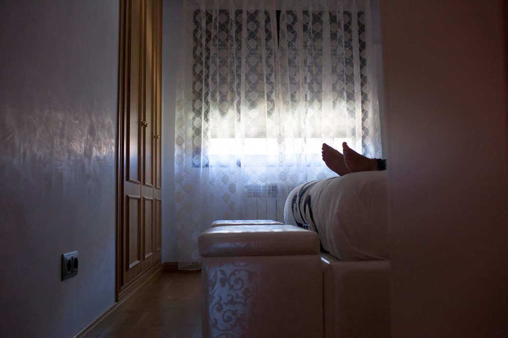 The feet of a woman with MS who is taking a rest on her bed