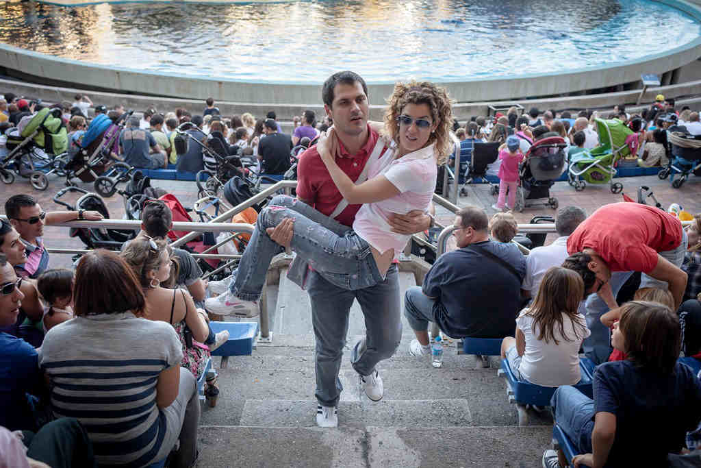 A man carries his wife, who has MS, up some steps at a zoo