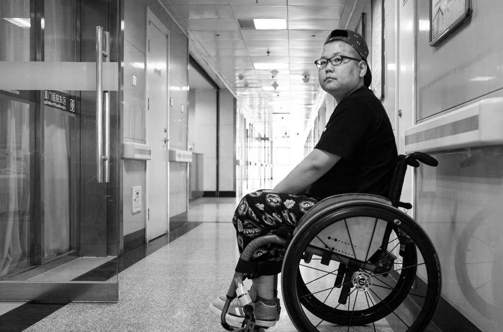 Woman in wheelchair in hospital corridor in China