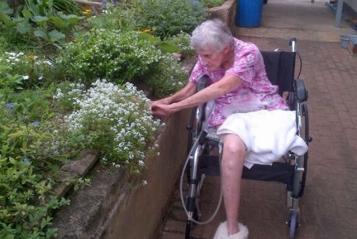 An elderly woman gardening in a wheelchair