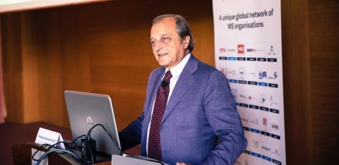 Professor Comi stands at a lecturn to give his presentation