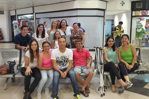 A group of people sit gather around a bench in an airport