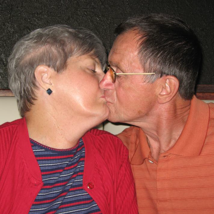 an older man and woman share a kiss
