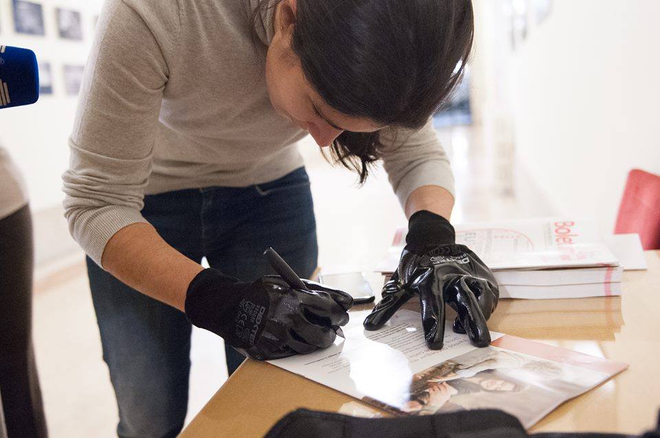 A Portuguese politician attempts to write whilst wearing heavy black gloves